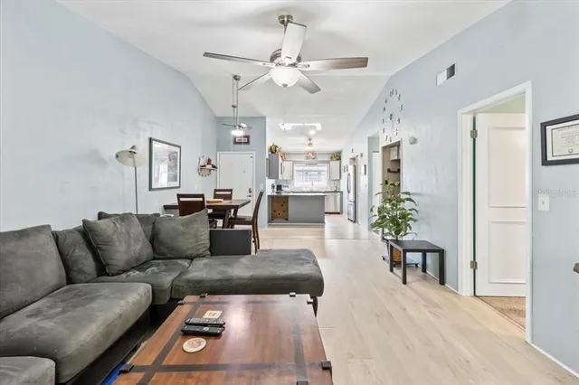 a living room with furniture kitchen view and a chandelier