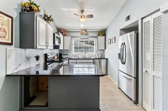 a kitchen with refrigerator cabinets and a sink