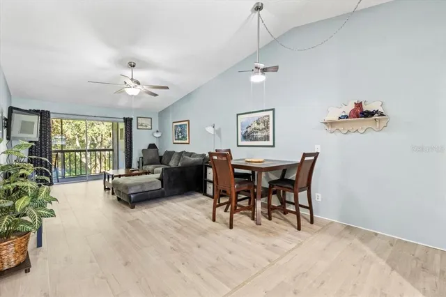 a view of a livingroom and a dining room with furniture window and wooden floor