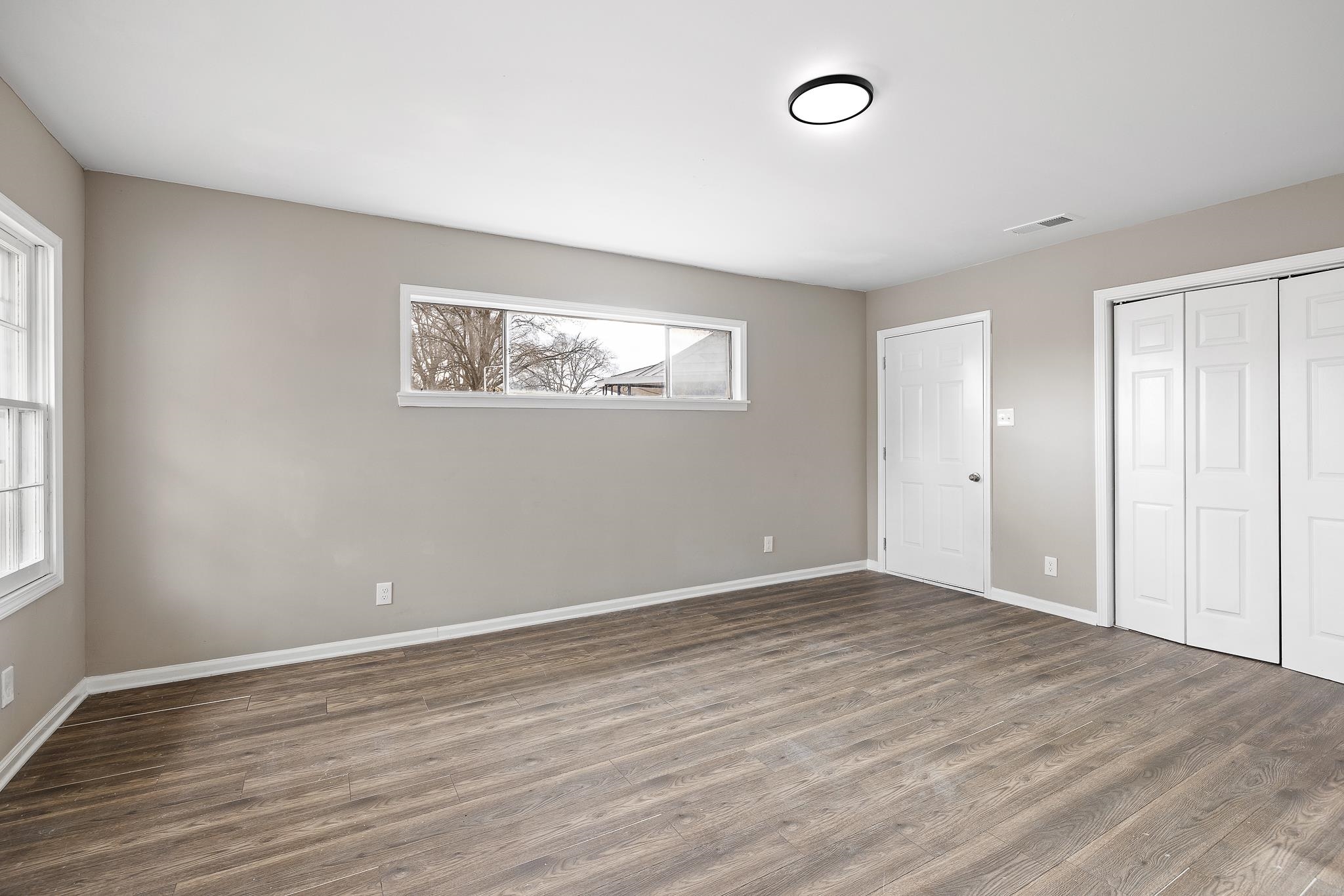 4375 Macon Road Memphis, TN 38122 - Photo 8 of 17 an empty room with wooden floor and windows
