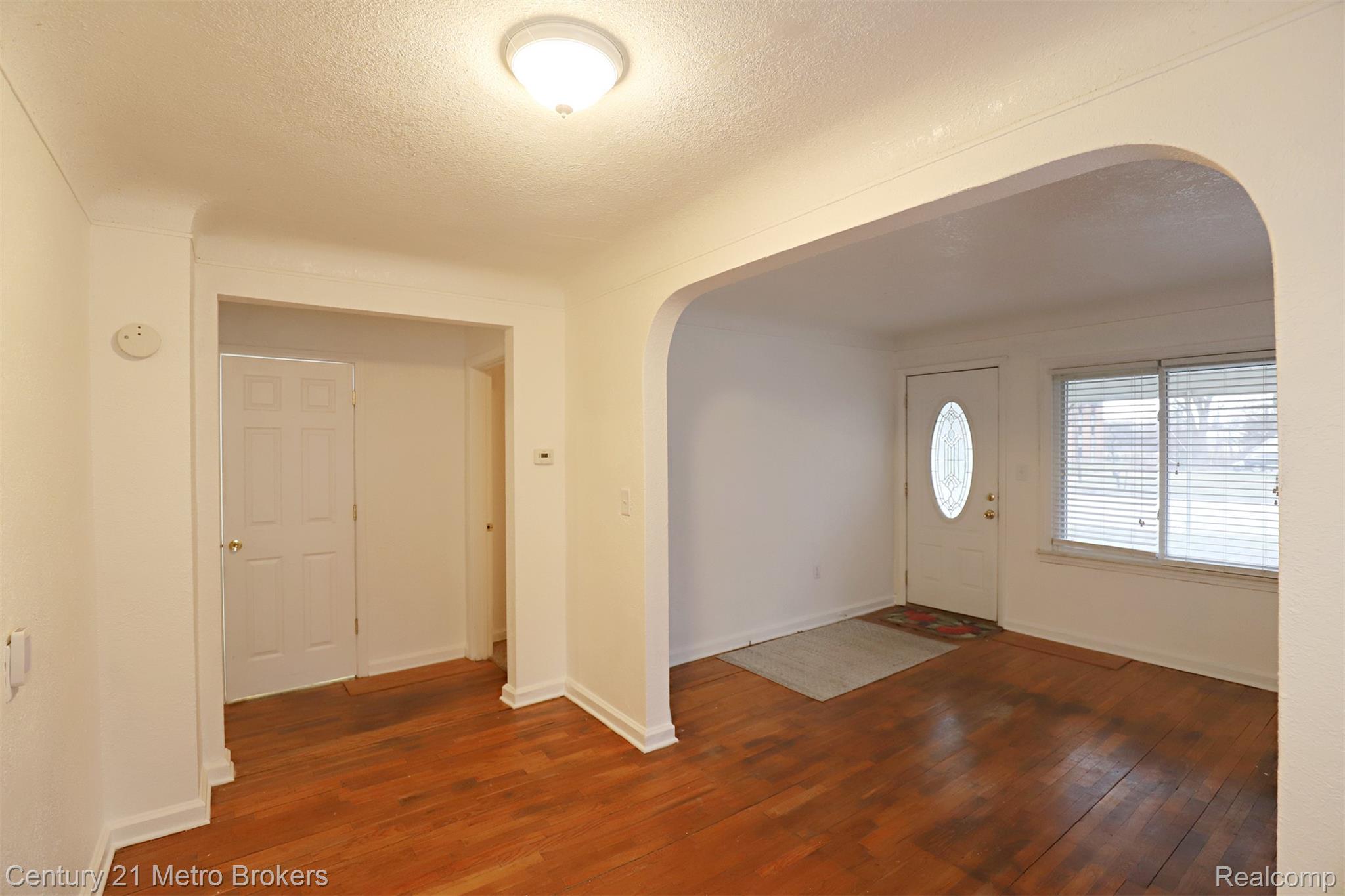 2074 North Center Road Burton, MI 48509 - Photo 3 of 20 Foyer entrance featuring arched walkways, a textured ceiling, and dark wood-type flooring