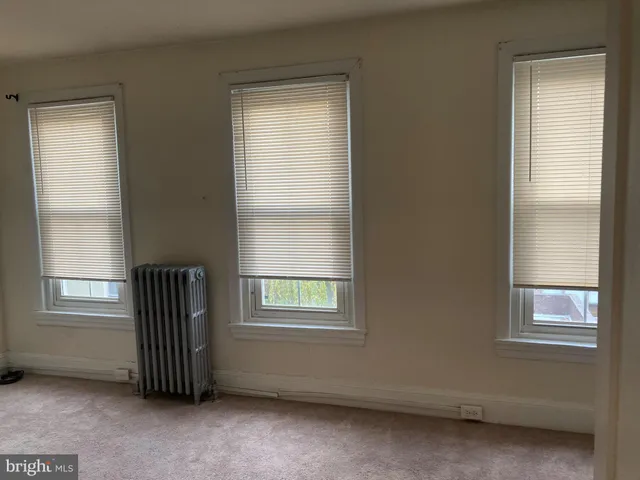 an empty room with a window and a ceiling fan