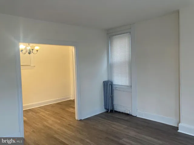 an empty room with wooden floor and a window