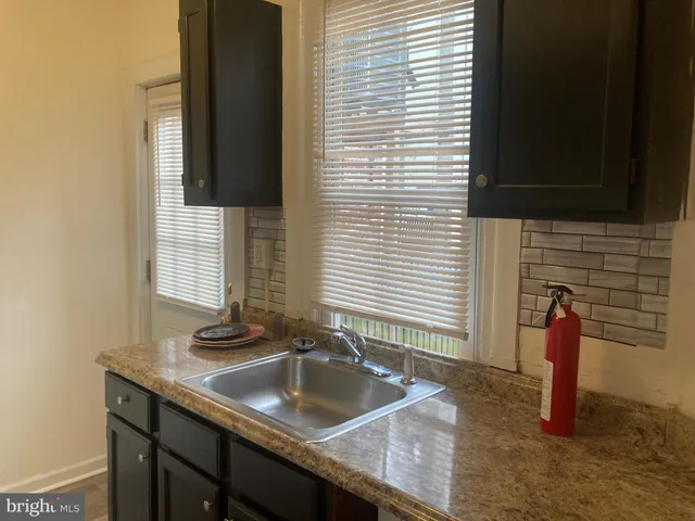 a kitchen with a sink and a wooden floor