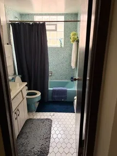 a bathroom with a sink a toilet a shower a mirror and