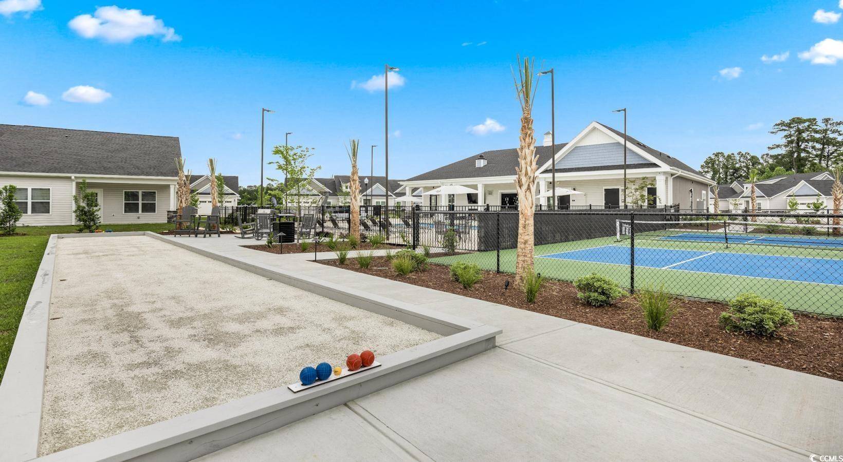 31 Quaker Rdg Drive, Unit MEANDER Carolina Shores, NC 28467 - Photo 14 of 38 View of tennis court with a residential view and a game area