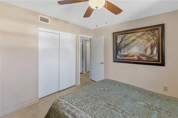 a bedroom with a bed and a painting on the wall