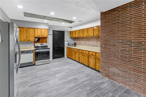 a kitchen with stainless steel appliances granite countertop a sink and a refrigerator