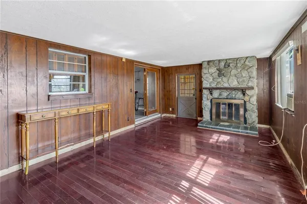 a view of a livingroom with wooden floor and a fireplace
