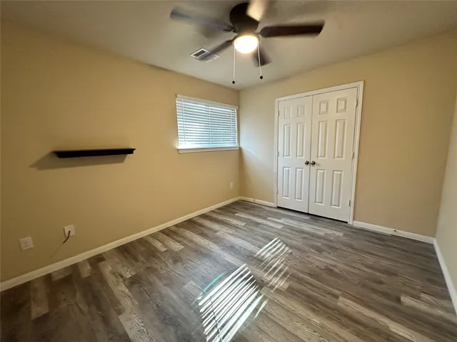 a view of a livingroom with wooden floor and a ceiling fan