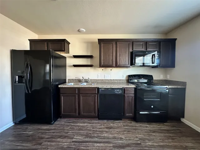 a kitchen with stainless steel appliances granite countertop a refrigerator and a stove