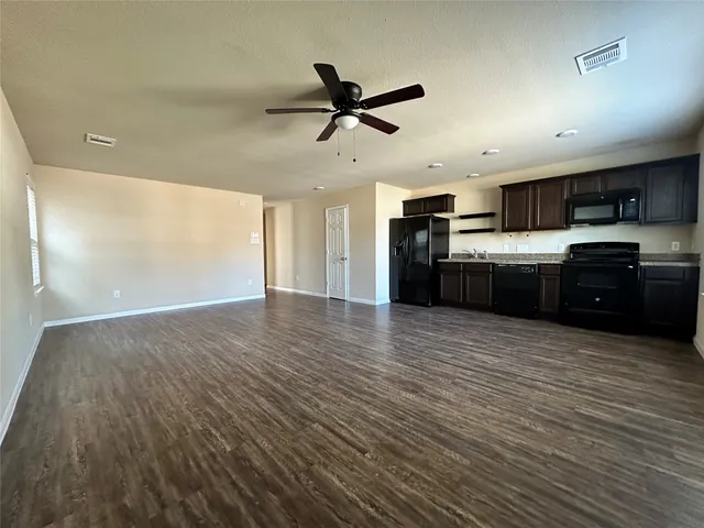 a large kitchen with stainless steel appliances granite countertop a sink and cabinets