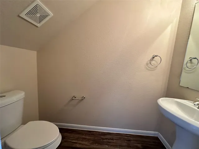a white toilet sitting next to a white wall