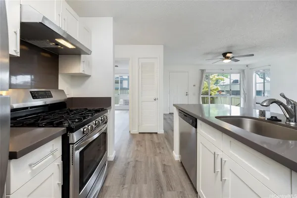 a kitchen with a sink stove top oven and cabinets