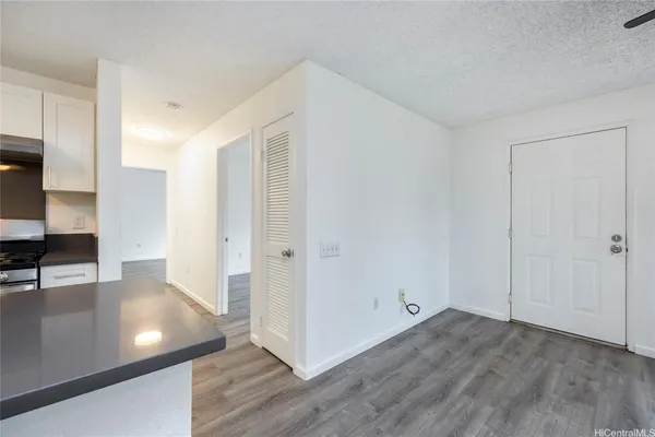 a view of a hallway to a room with wooden floor