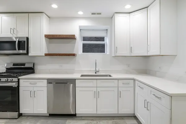 a kitchen with white cabinets and a sink