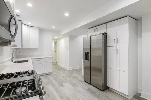 a kitchen with stainless steel appliances a refrigerator and a stove top oven