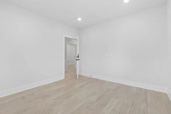 a view of a hallway with wooden floor and a window