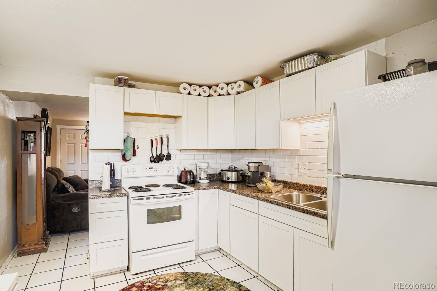 7111 Raleigh Street Westminster, CO 80030 - Photo 13 of 38 a kitchen with white cabinets and white appliances
