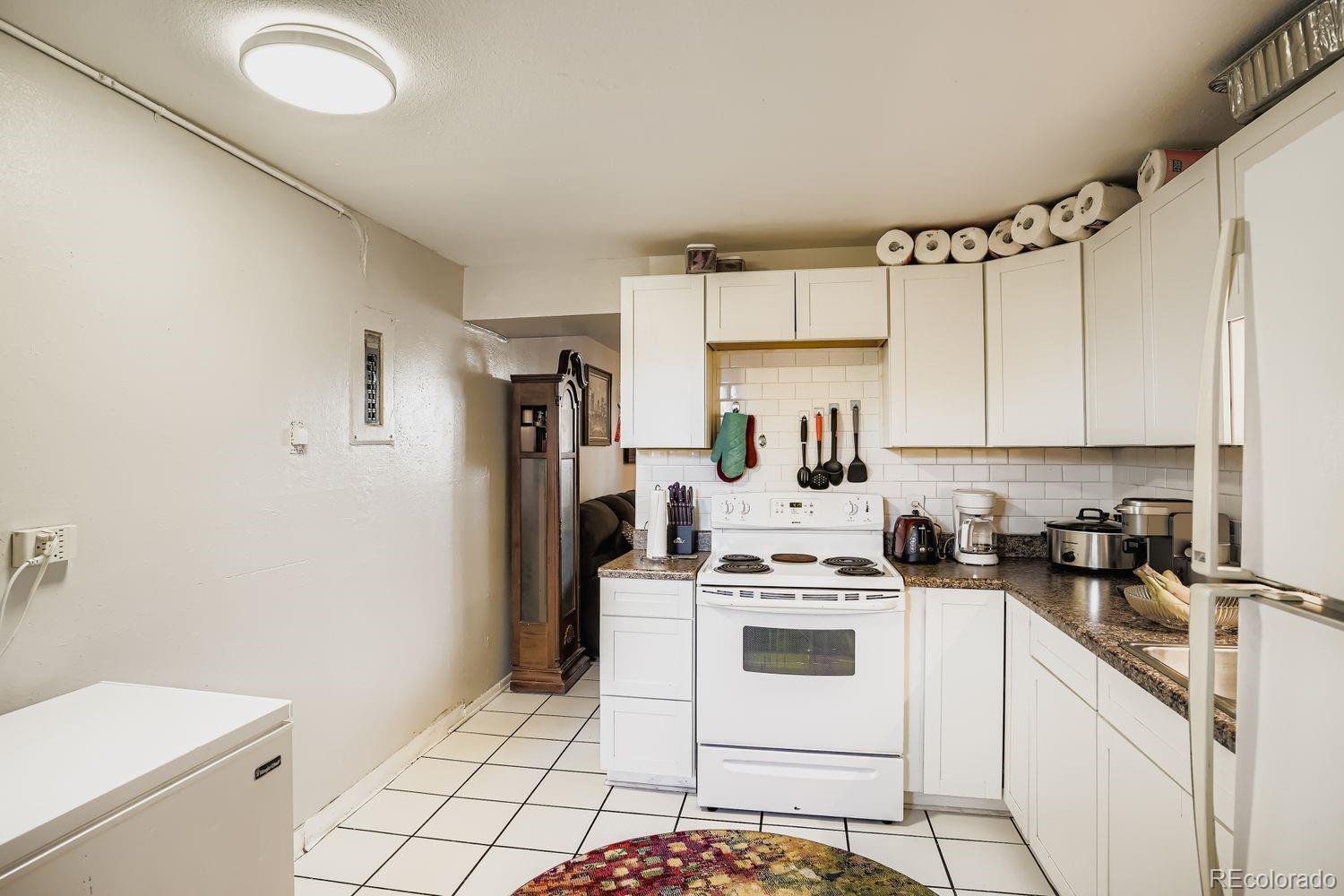 7111 Raleigh Street Westminster, CO 80030 - Photo 14 of 38 a kitchen with white cabinets and white appliances