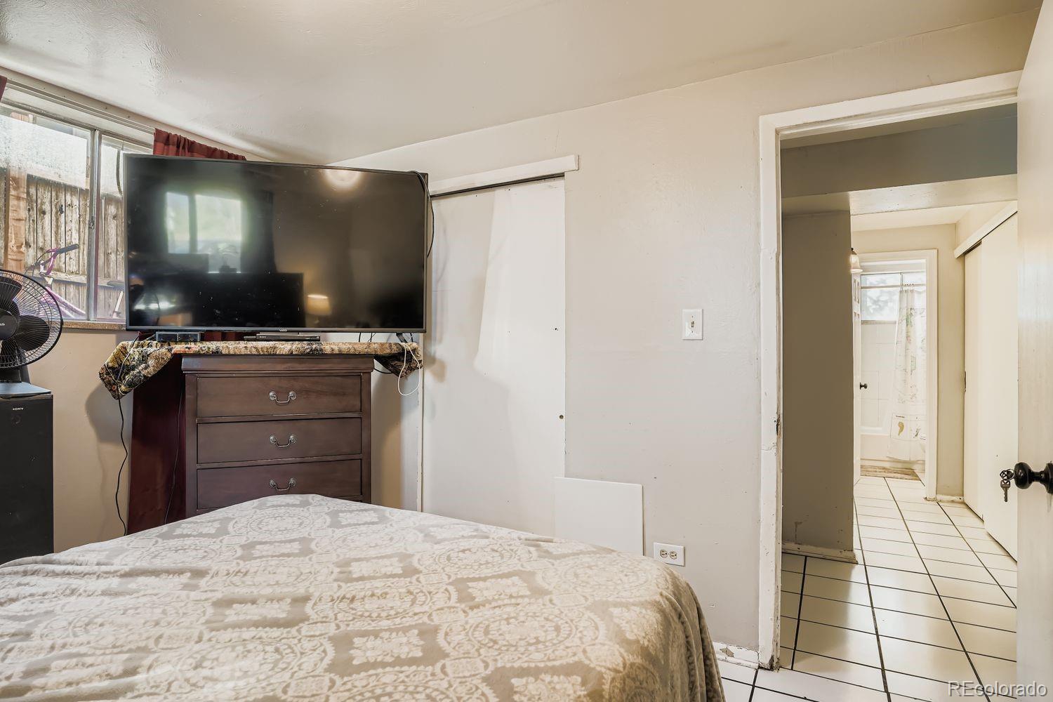 7111 Raleigh Street Westminster, CO 80030 - Photo 21 of 38 a bedroom with a bed and a flat screen tv