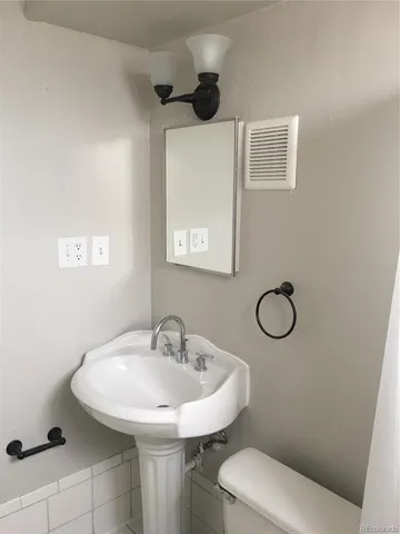 a bathroom with a sink a toilet and a mirror