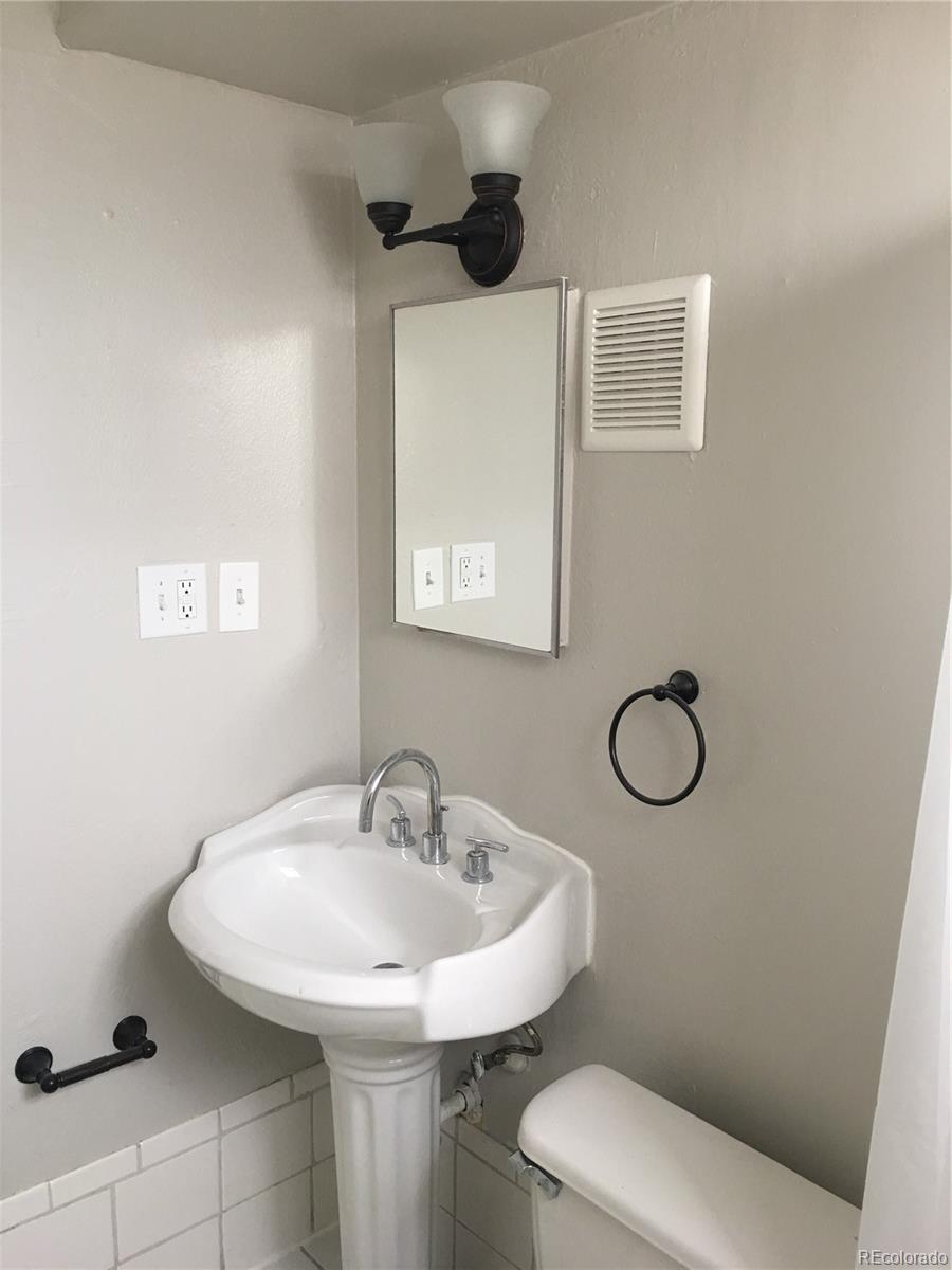 7111 Raleigh Street Westminster, CO 80030 - Photo 27 of 38 a bathroom with a sink a toilet and a mirror