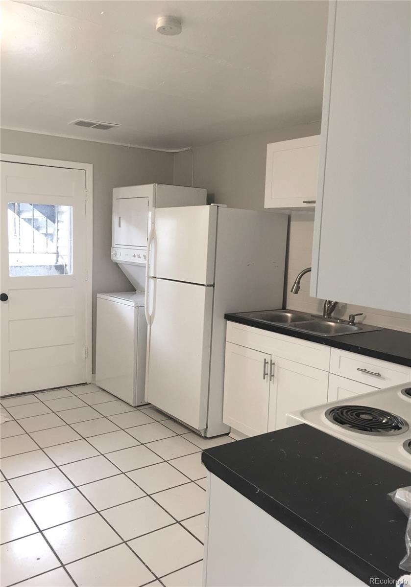 7111 Raleigh Street Westminster, CO 80030 - Photo 28 of 38 a white refrigerator freezer sitting in a kitchen