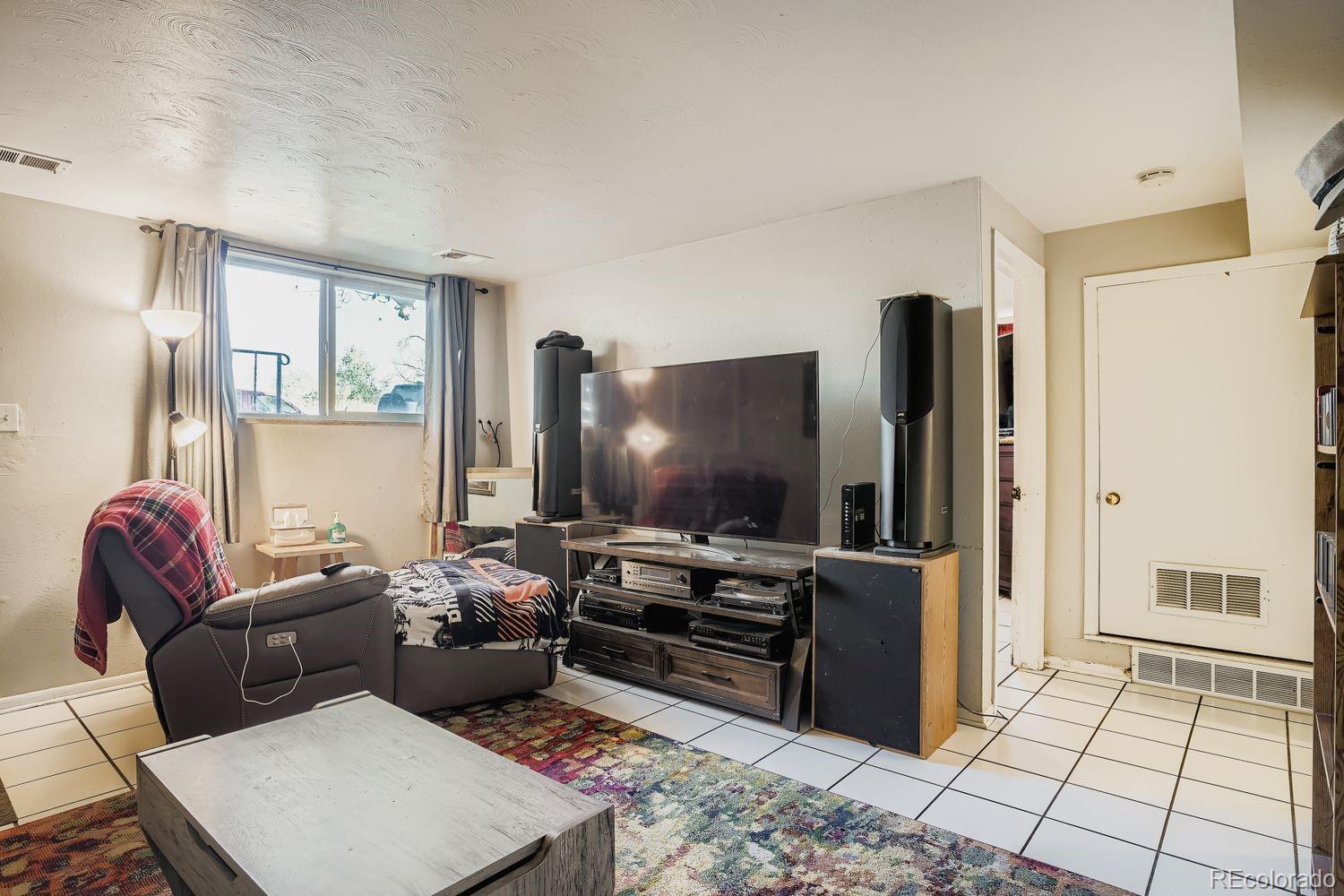 7111 Raleigh Street Westminster, CO 80030 - Photo 10 of 38 a living room with furniture and a flat screen tv