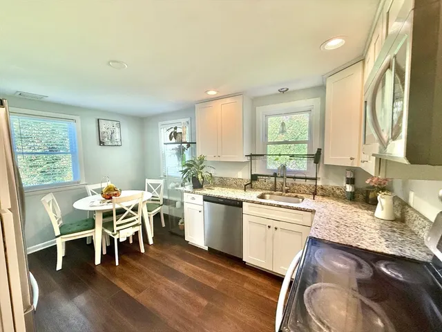 a living room with furniture large window and wooden floor