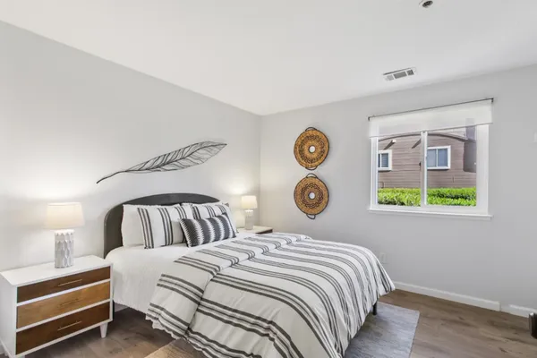 a bedroom with a bed and painting on the wall