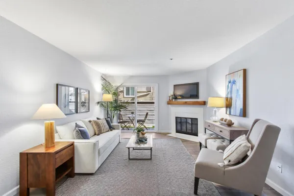 a living room with furniture a flat screen tv and a fireplace