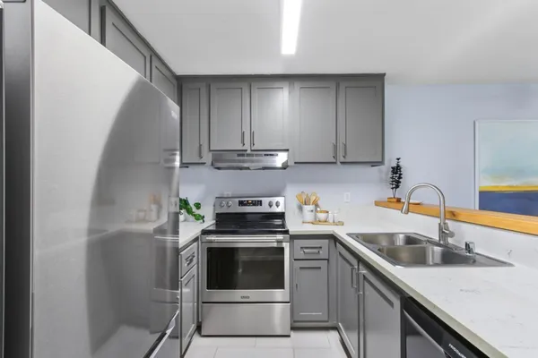 a kitchen with stainless steel appliances granite countertop a sink stove and cabinets