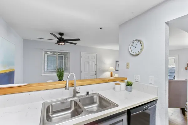 a kitchen with a sink a clock and cabinets