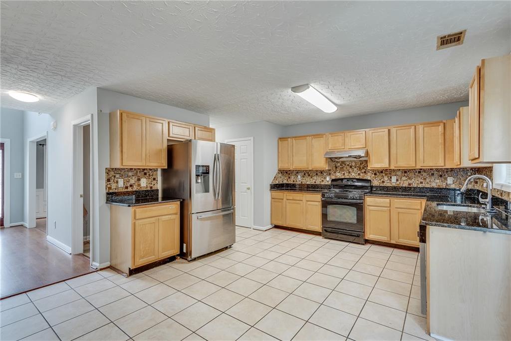 3337 Baymount Way Lawrenceville, GA 30043 - Photo 12 of 47 a kitchen with a refrigerator and white cabinets