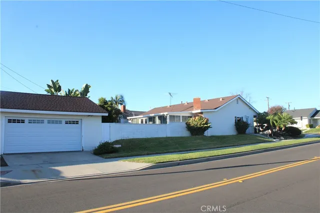 a front view of a house with a garden and parking space