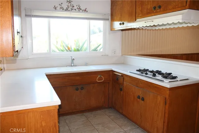 a view of kitchen with stainless steel appliances wooden floor and chair