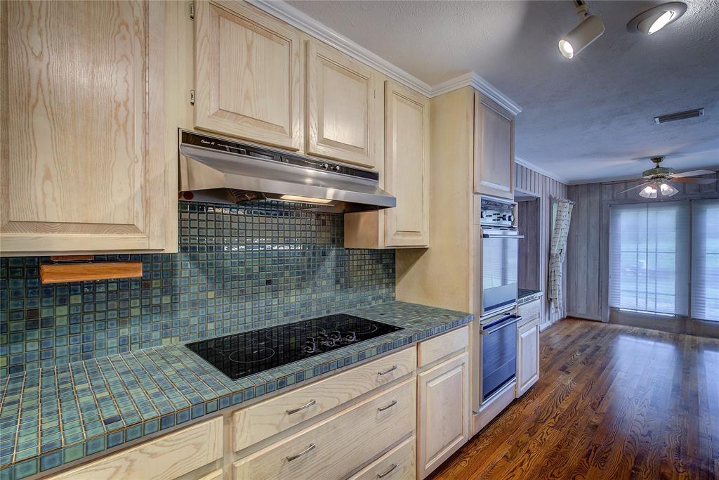 18 Mullaney Road Greenville, TX 75402 - Photo 14 of 37 a kitchen with granite countertop a sink stainless steel appliances wooden floor and cabinets