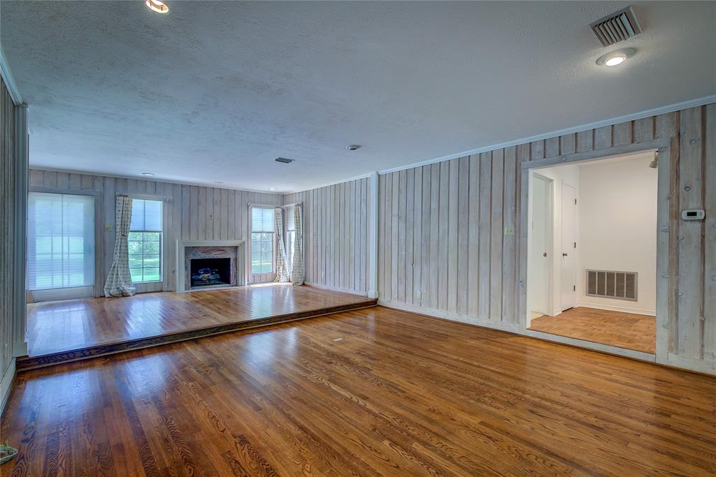 18 Mullaney Road Greenville, TX 75402 - Photo 4 of 37 a view of empty room with wooden floor and fireplace