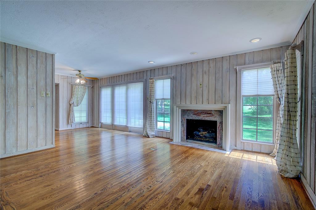 18 Mullaney Road Greenville, TX 75402 - Photo 6 of 37 a view of an empty room with wooden floor fireplace and a window