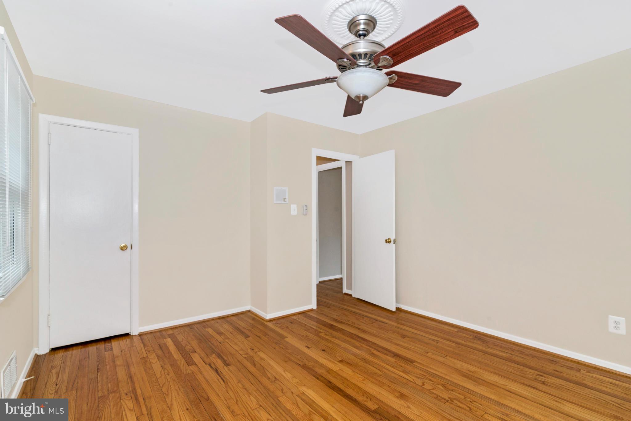 2801 Weisman Road Silver Spring, MD 20902 - Photo 11 of 30 an empty room with wooden floor and ceiling fan