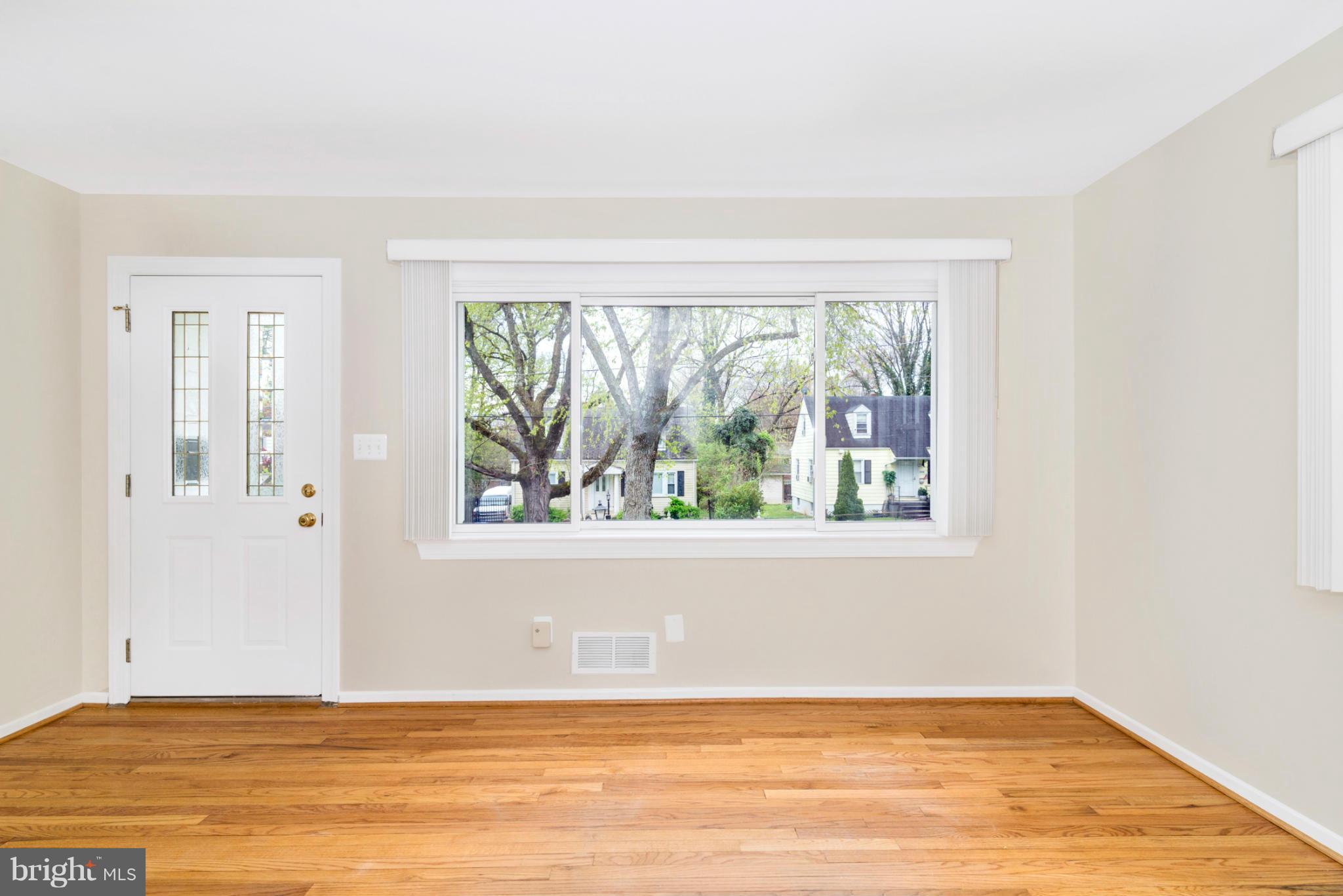 2801 Weisman Road Silver Spring, MD 20902 - Photo 5 of 30 an empty room with wooden floor and a window