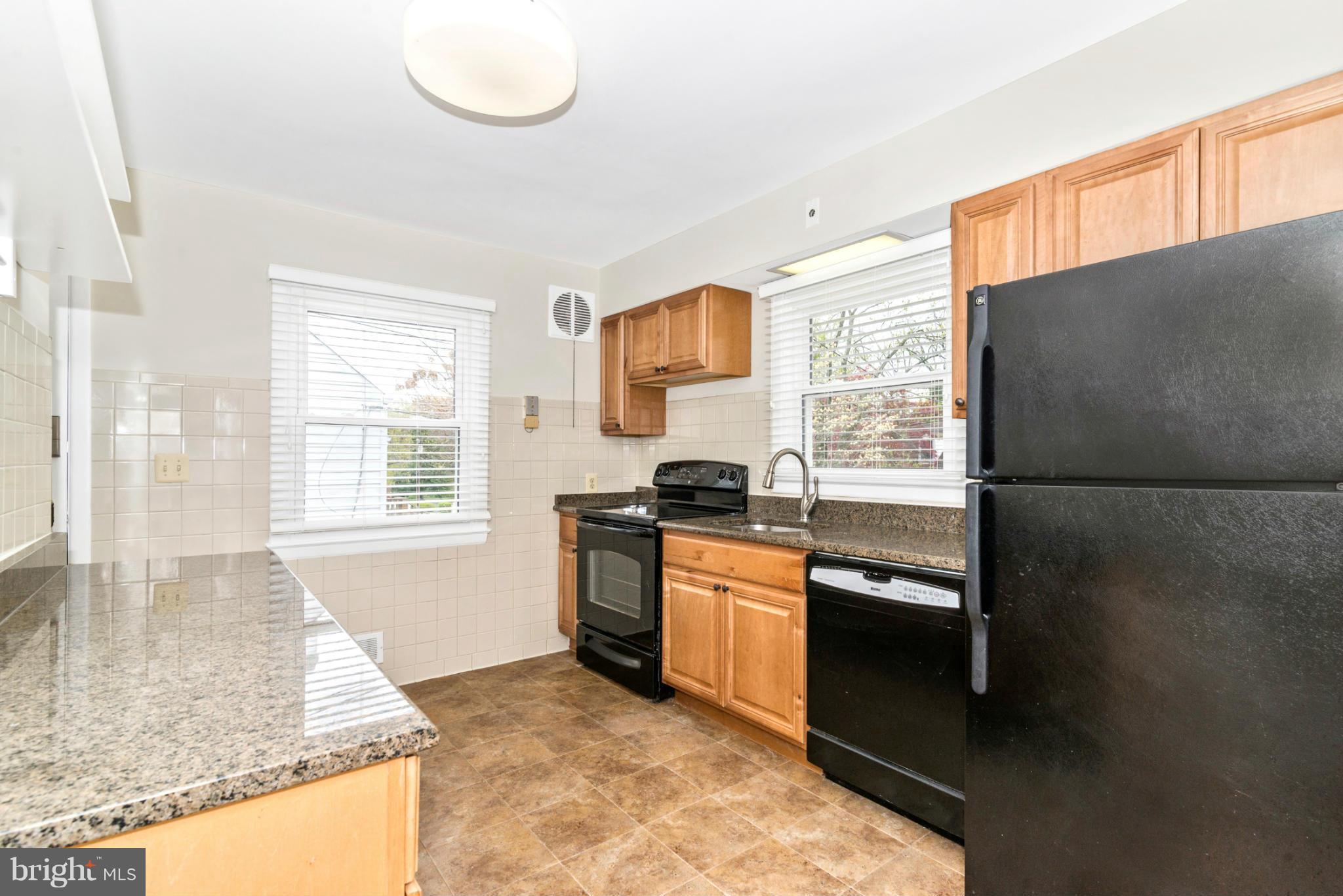 2801 Weisman Road Silver Spring, MD 20902 - Photo 6 of 30 a kitchen with granite countertop a refrigerator and a sink