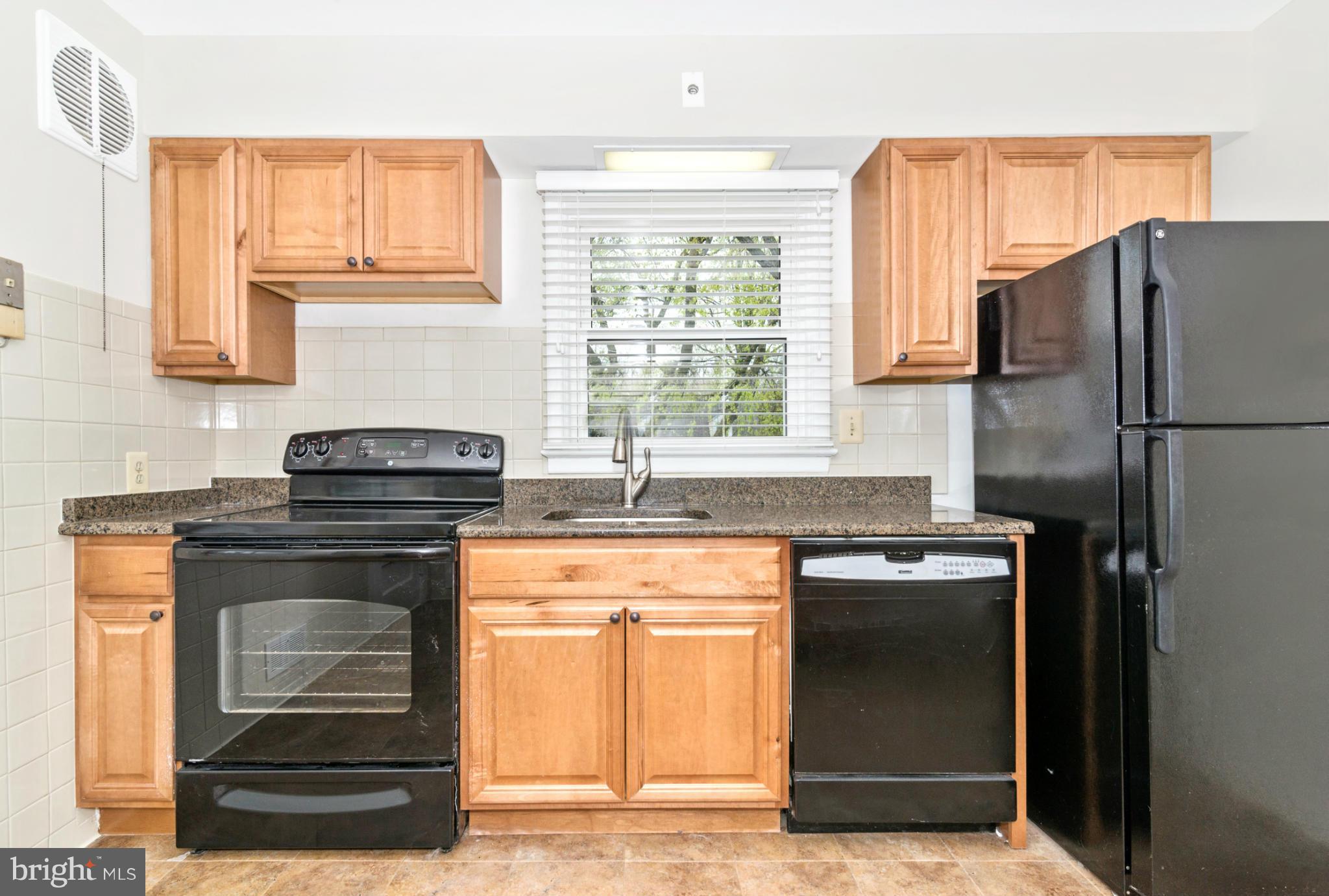 2801 Weisman Road Silver Spring, MD 20902 - Photo 7 of 30 a kitchen with granite countertop a refrigerator stove and sink