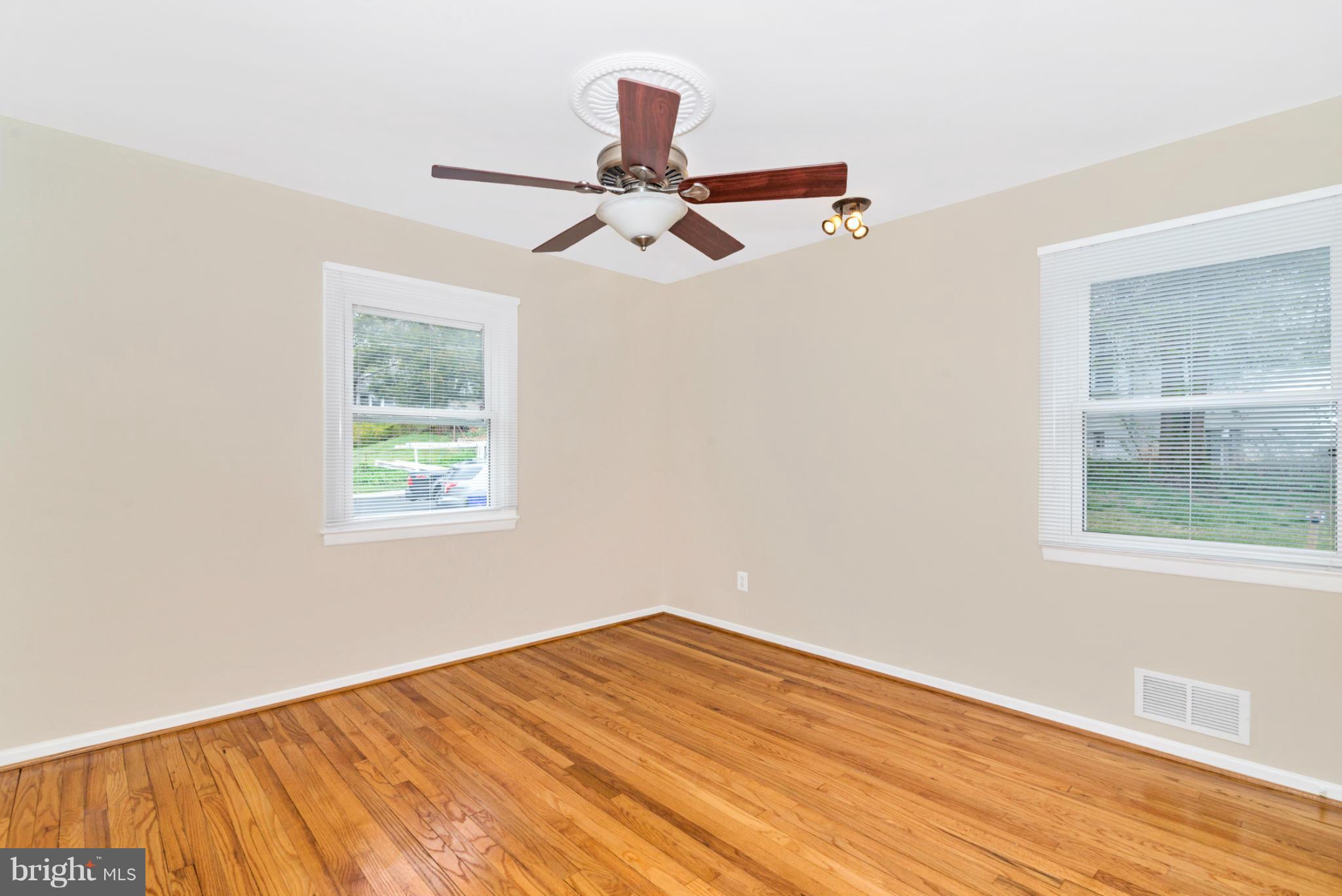 2801 Weisman Road Silver Spring, MD 20902 - Photo 9 of 30 an empty room with wooden floor ceiling fan and windows