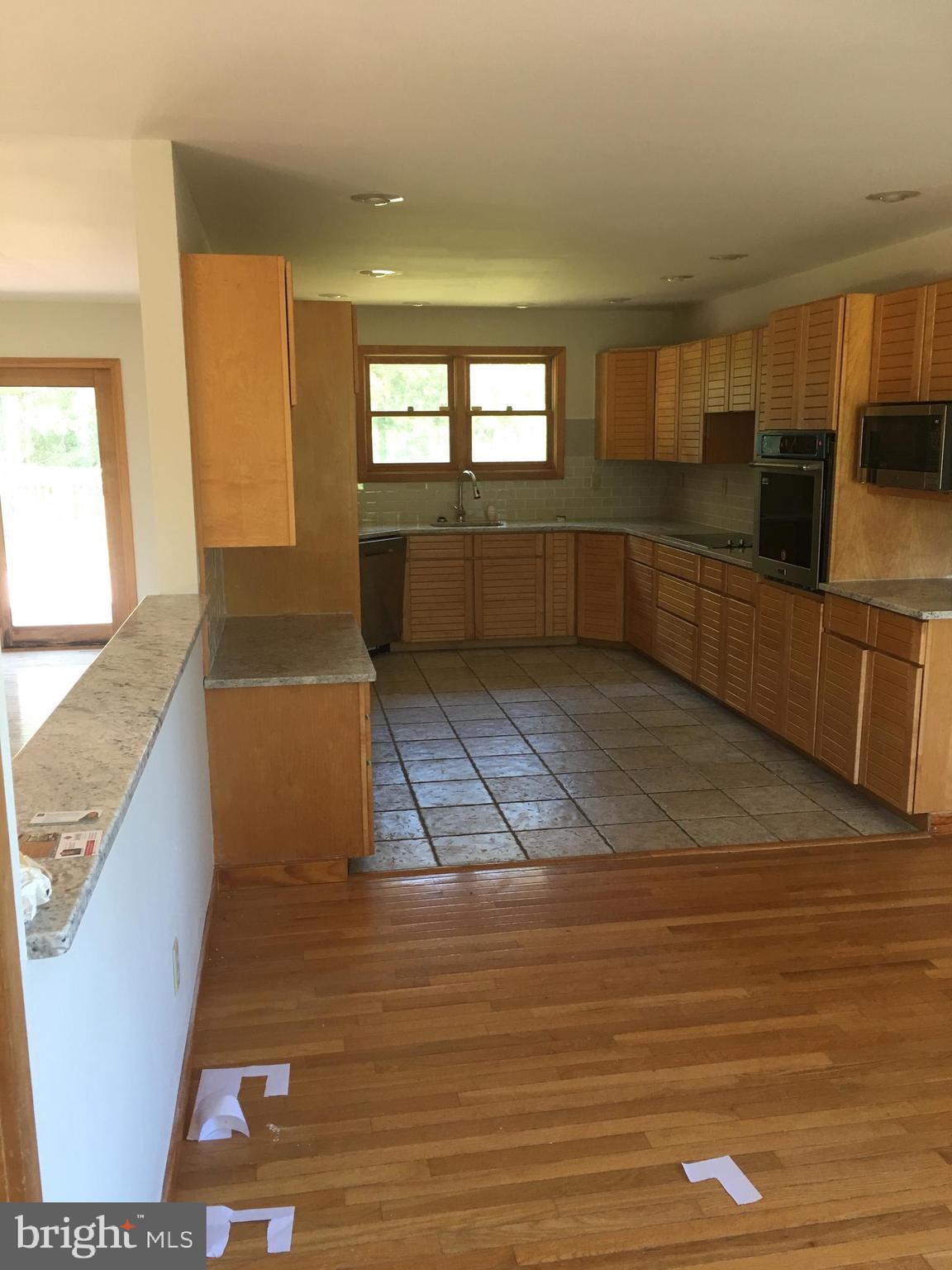 561 Mullica Hill Road Glassboro, NJ 08028 - Photo 3 of 20 a view of a kitchen with kitchen island wooden floor and living room