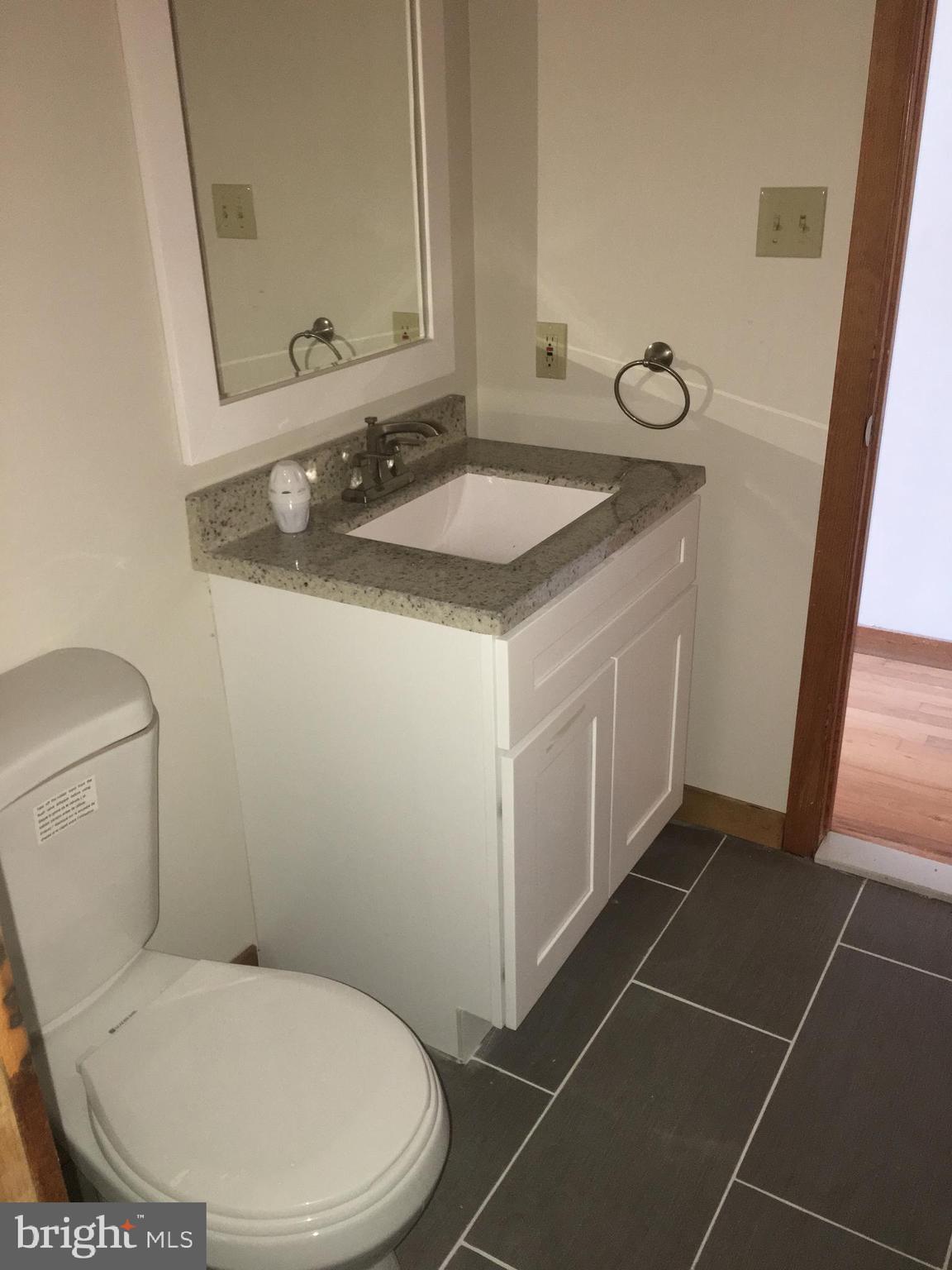 561 Mullica Hill Road Glassboro, NJ 08028 - Photo 6 of 20 a bathroom with a sink toilet and mirror