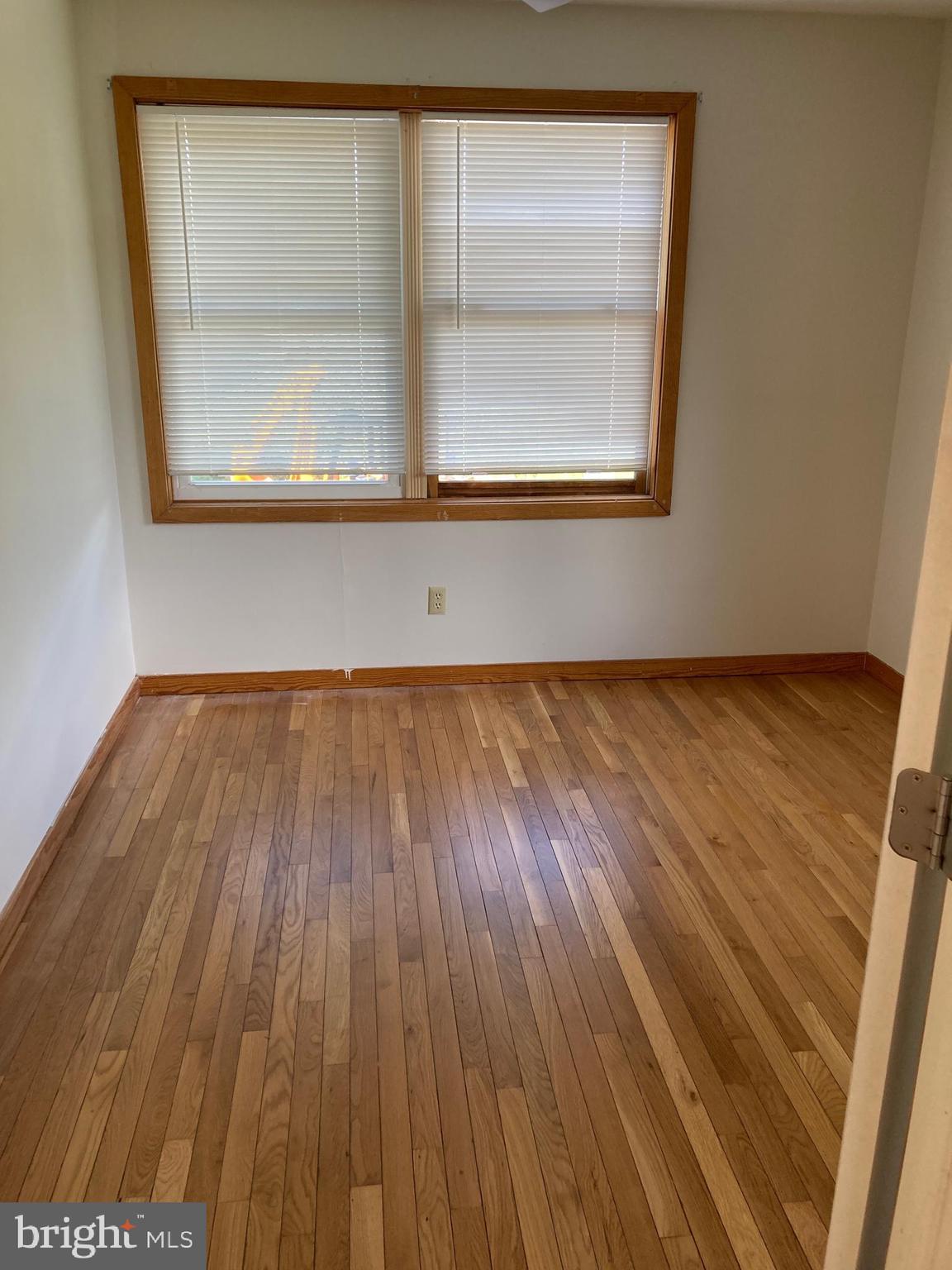 561 Mullica Hill Road Glassboro, NJ 08028 - Photo 10 of 20 an empty room with wooden floor and a window