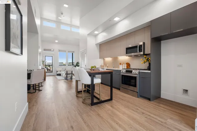 a living room with stainless steel appliances kitchen island furniture and a wooden floor