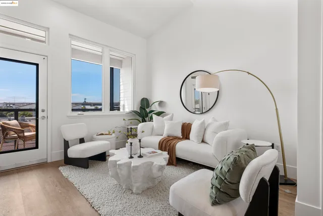 a living room with furniture a mirror and a potted plant